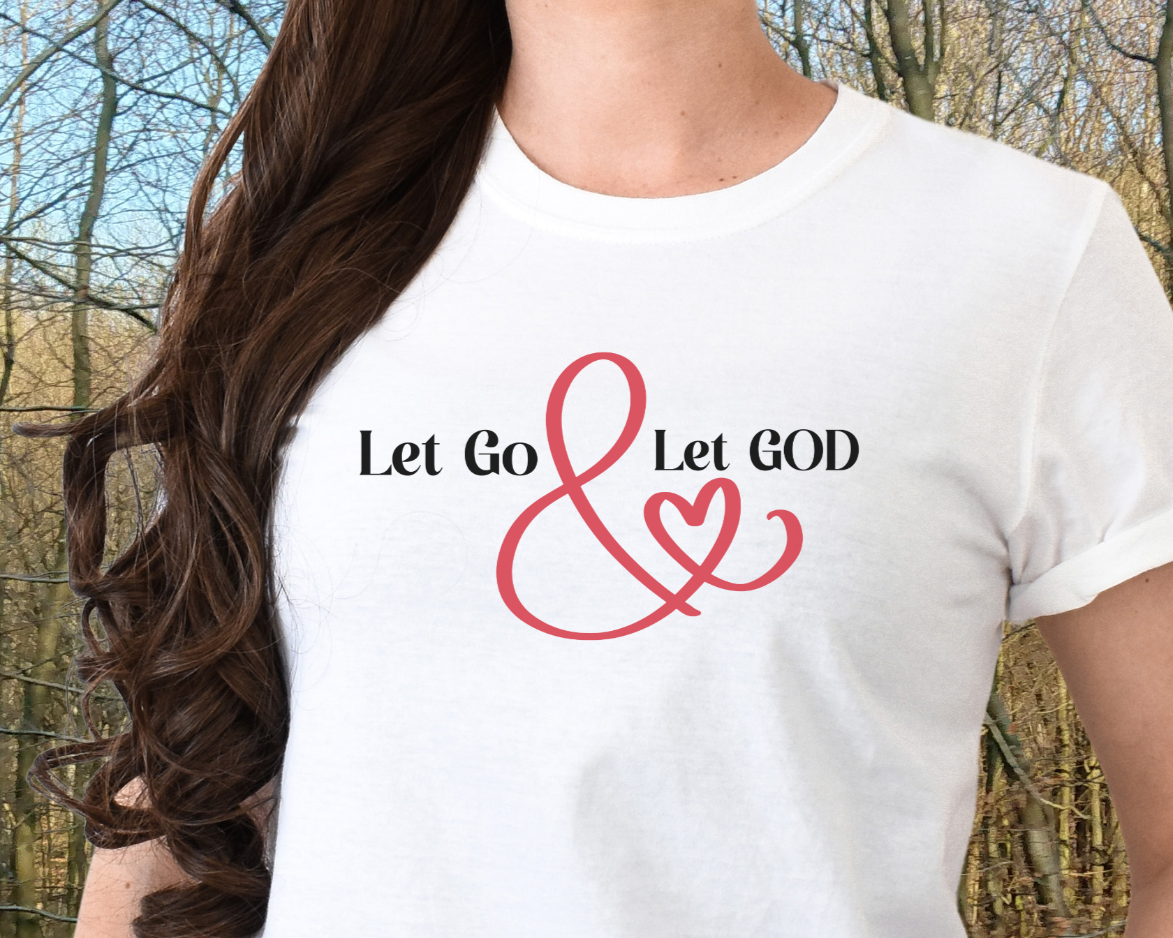 White t-shirt with the phrase ‘Let Go & Let God’ in bold black text and a red ampersand forming a heart. Cozy, inspirational faith-based apparel for everyday wear.