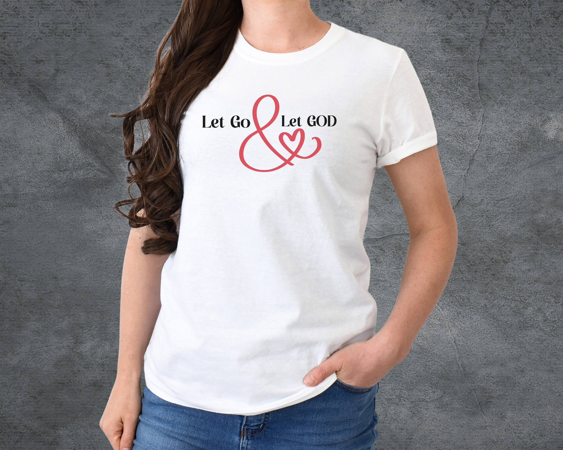 White t-shirt with the phrase ‘Let Go & Let God’ in bold black text and a red ampersand forming a heart. Cozy, inspirational faith-based apparel for everyday wear.