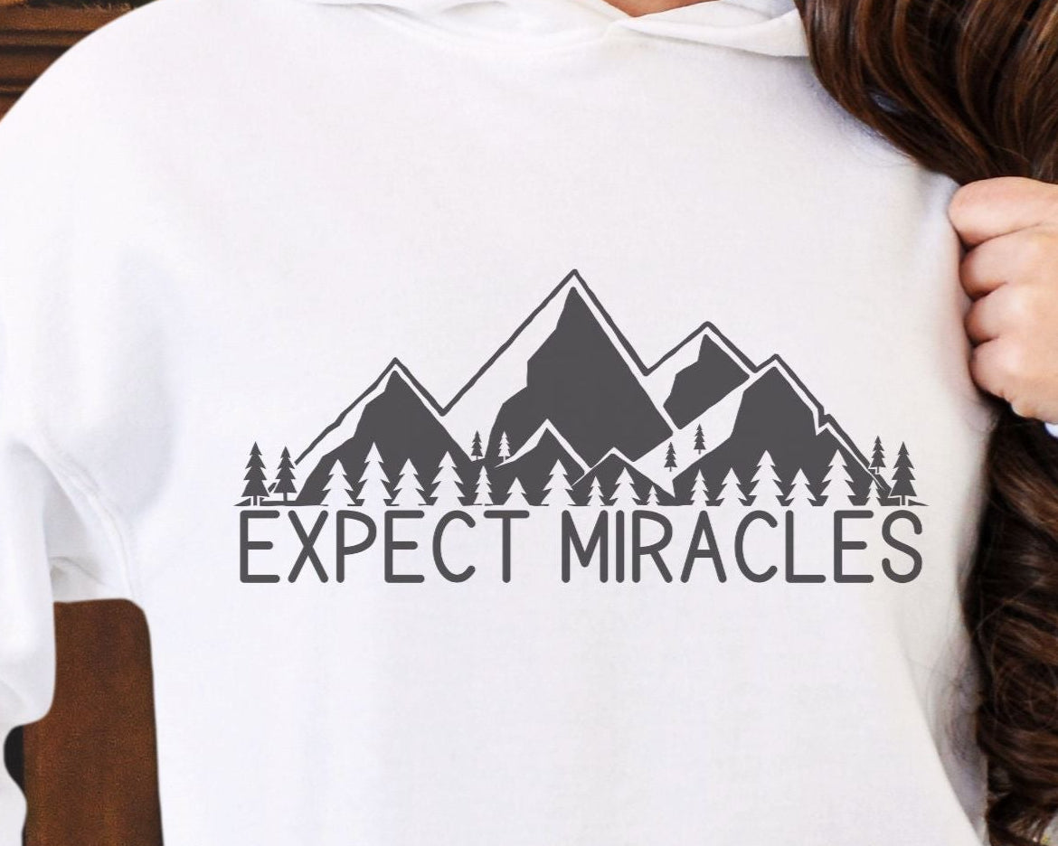 Closeup view of Expect Miracles hoodie graphic